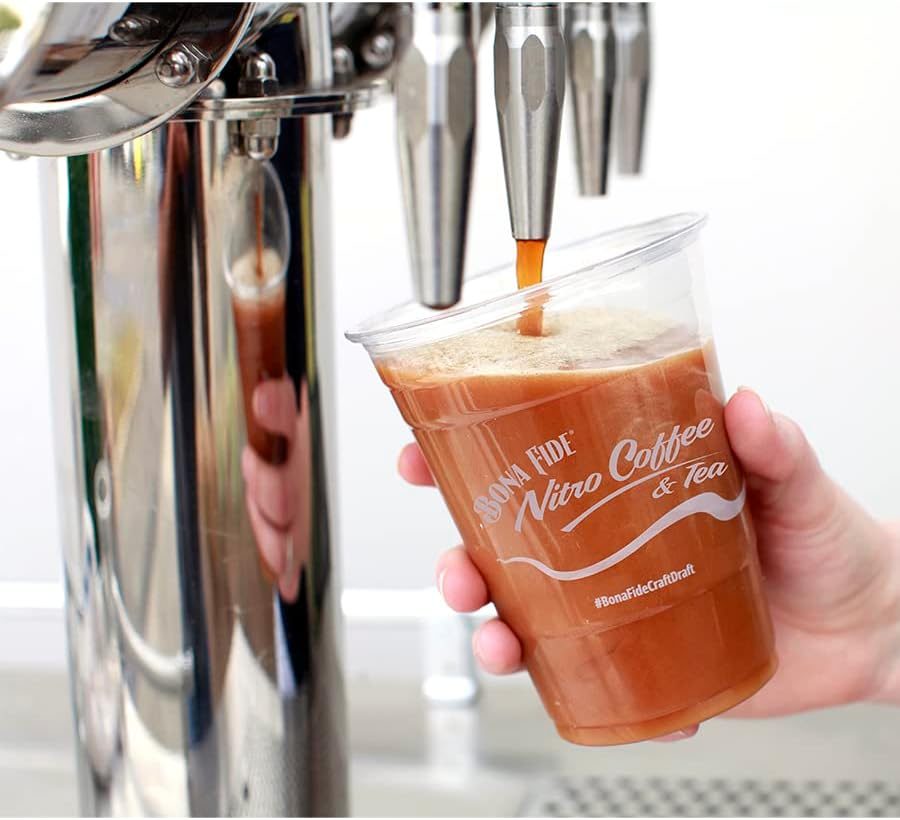 Nitro coffee poured on tap into a clear cup